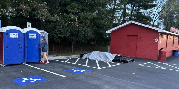 Freshman Margaret Moreland opens the door to a porta-potty next to the concession stand.