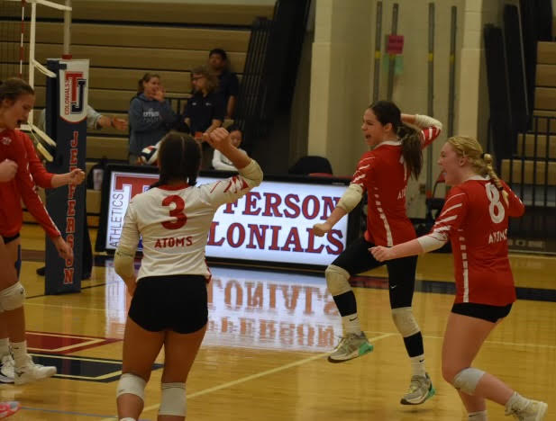 The girls volleyball team cheers after defeating the Thomas Jefferson Colonials 3-0