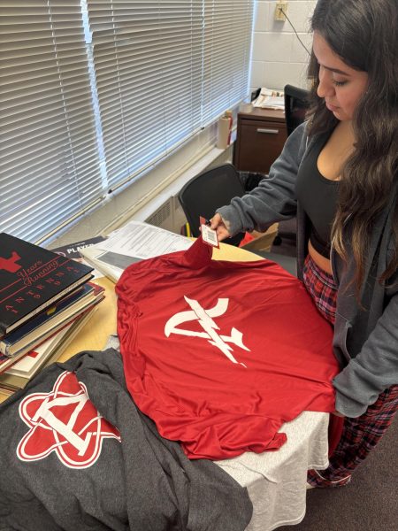 Senior Allison Rodas looking at merch and deciding which one she wants to buy.