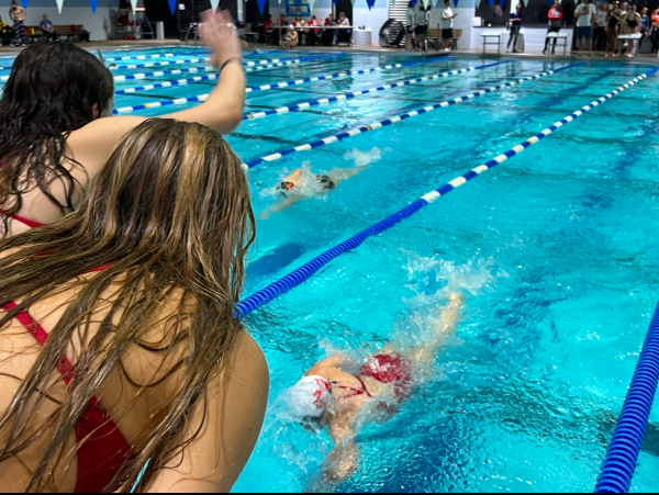 Alumni Bridget Murray and Jana Russell cheer on their teamates as she finishes a race during the 2023/2024 season.