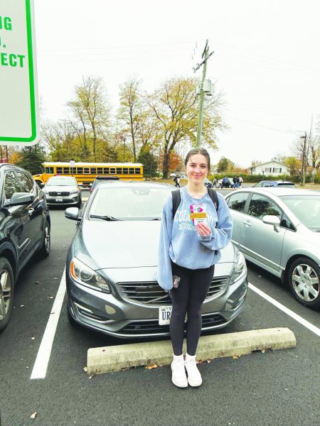 Junior Elizabeth Gronberg displays her parking passes that allow her to park at the Ossian Hall parking lot.