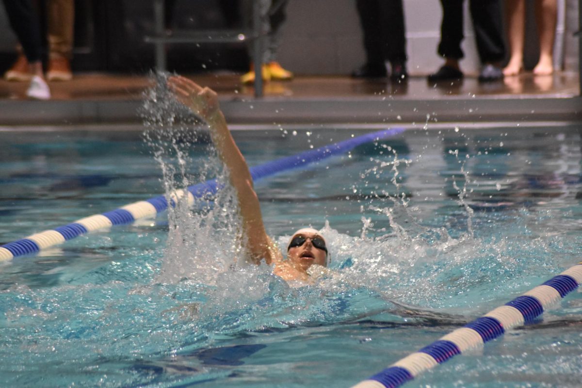 Noah Popp swimming backstroke during a regular season swim meet at Franconia Rec Center